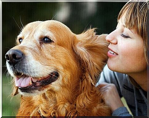 Woman whispers in her dog's ear